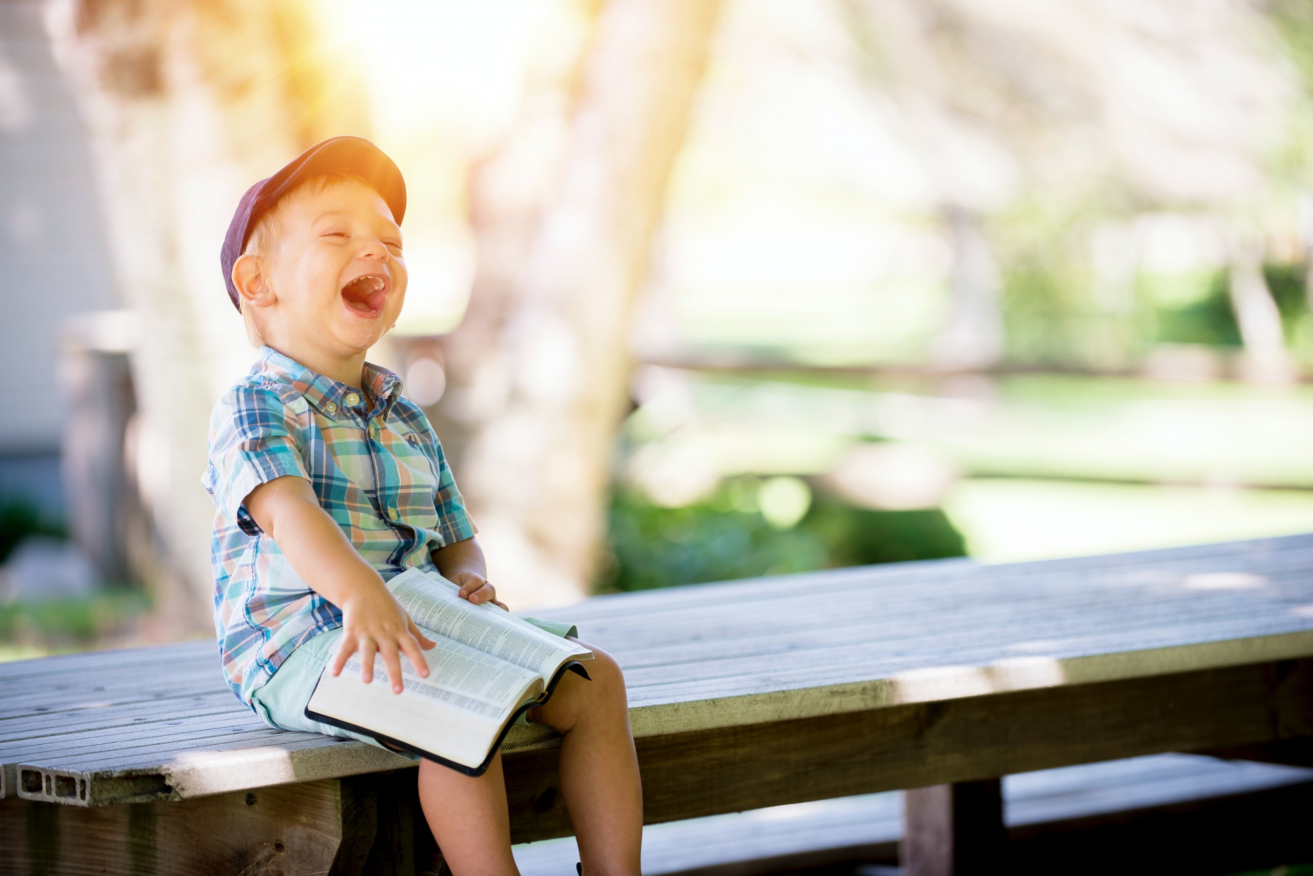 Enfant qui rit avec un livre à la main